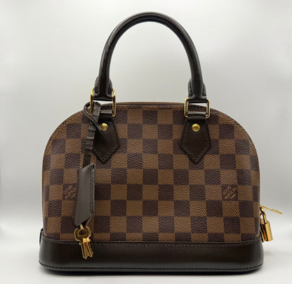 Louis Vuitton Alma BB in Damier Ebène coated canvas, front view showing structured silhouette and gold-tone LV padlock