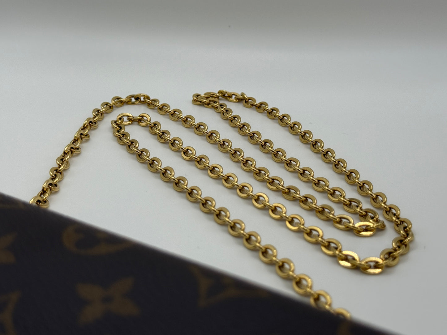 Close-up of the removable gold-tone chain strap on the Louis Vuitton Félicie Pochette