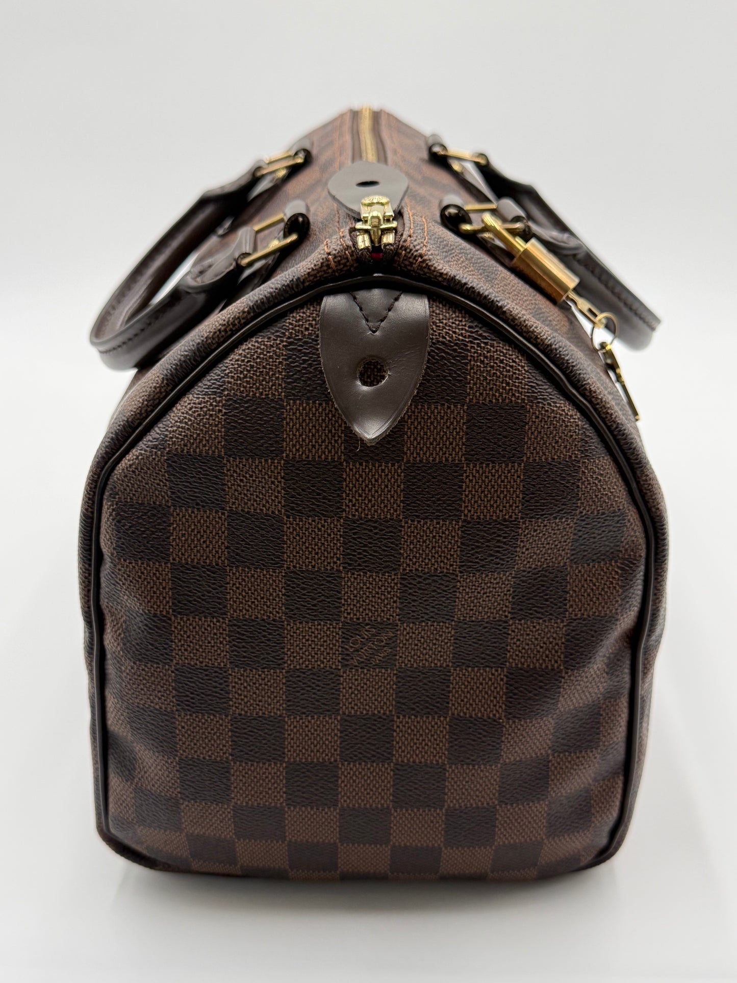 Close-up of the leather handles, gold padlock, and zipper pull on the Louis Vuitton Speedy 30