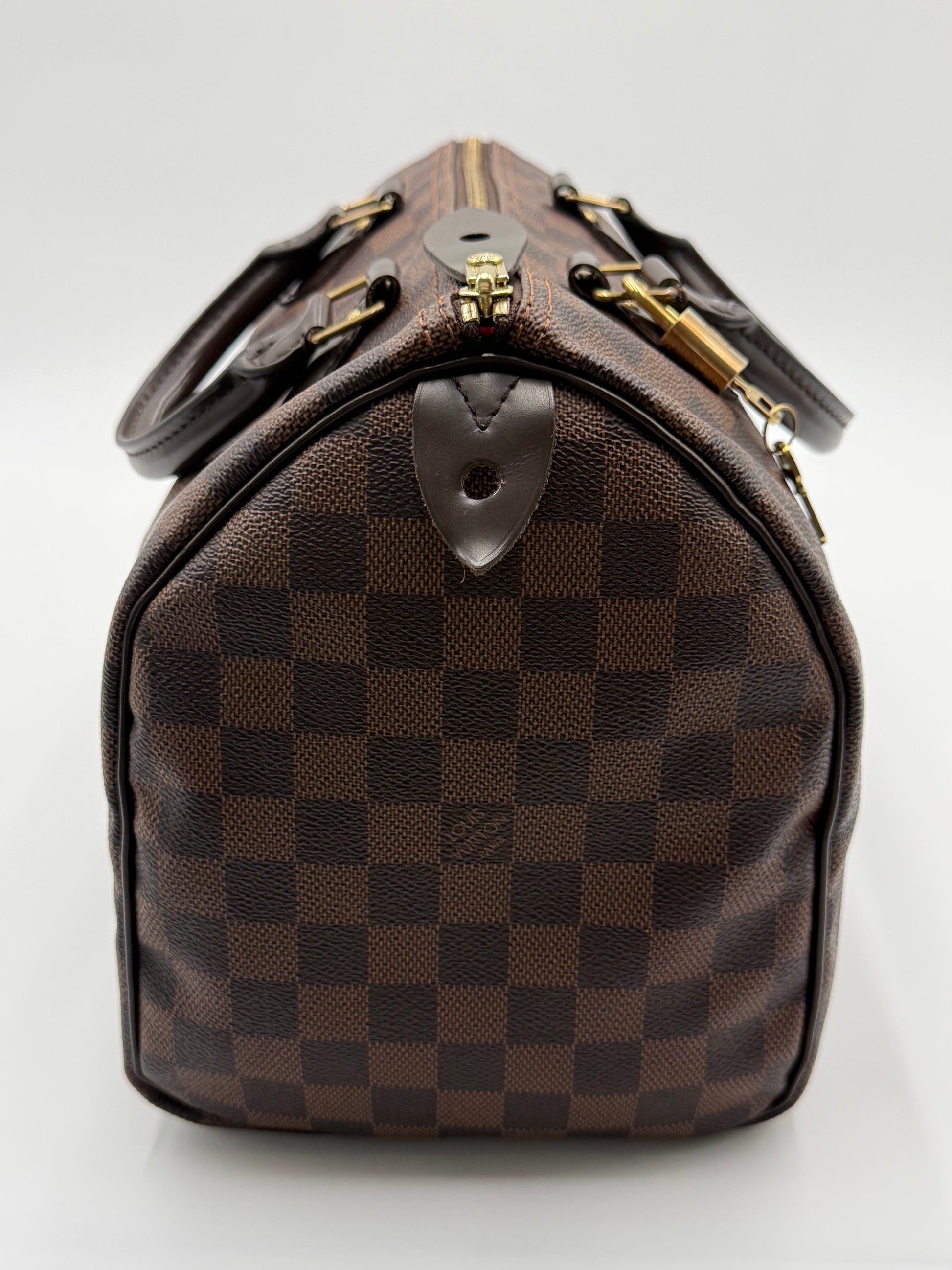 Close-up of the leather handles, gold padlock, and zipper pull on the Louis Vuitton Speedy 30