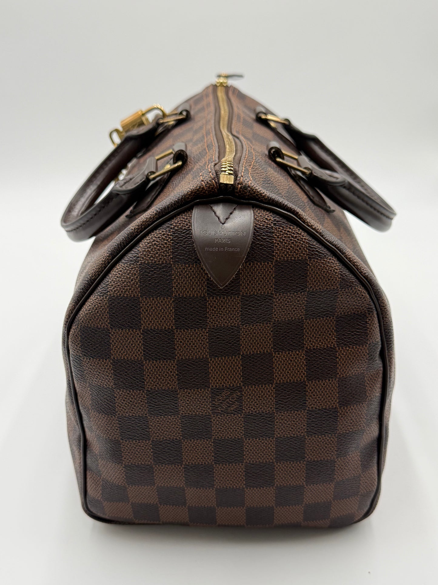 Louis Vuitton Speedy 30 handles and gold-tone hardware detail, showing brass zipper pull