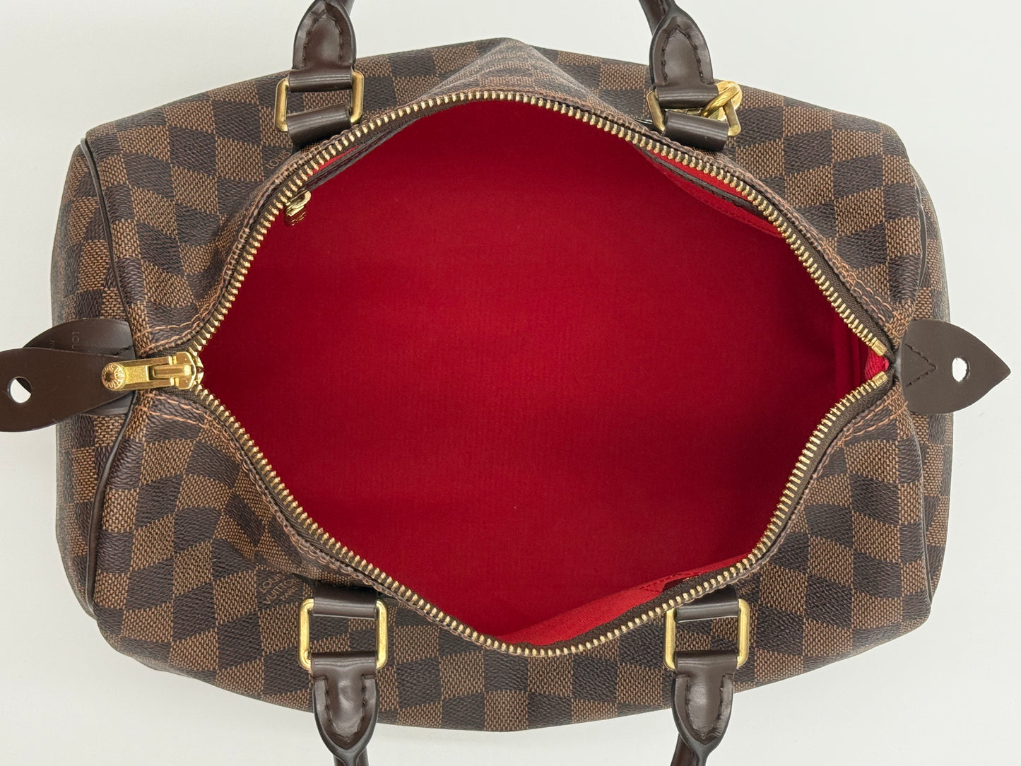 Full interior view of the Louis Vuitton Speedy 30, showing red lining and interior straps