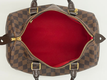 Full interior view of the Louis Vuitton Speedy 30, showing red lining and interior straps