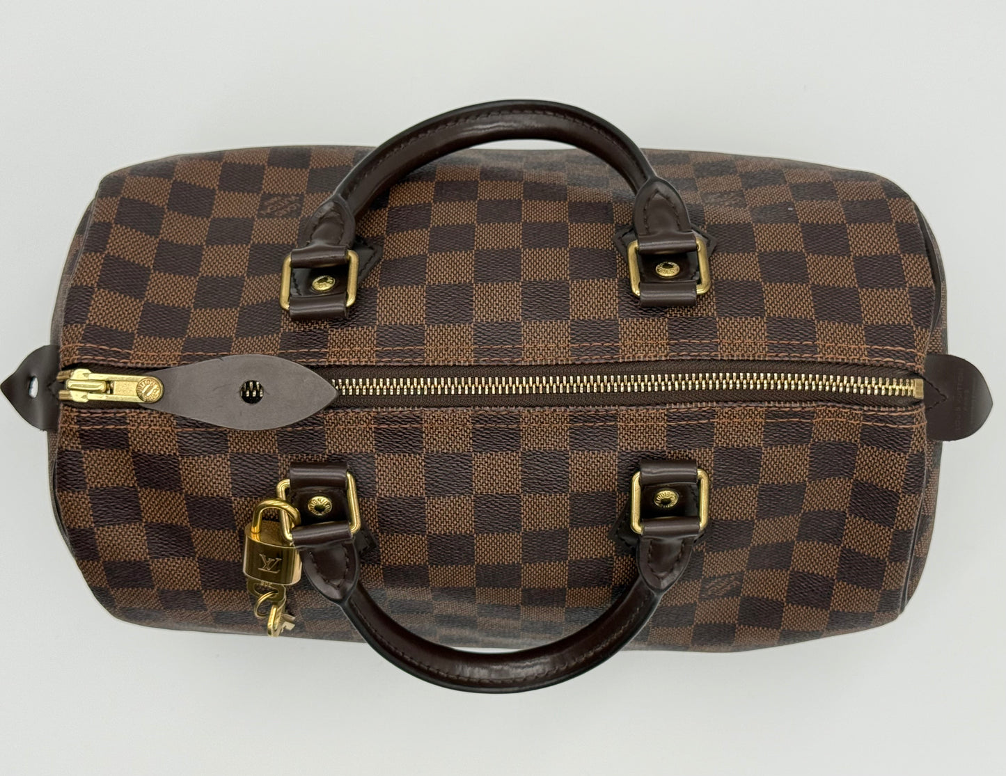 Louis Vuitton Speedy 30 shown at an angle, highlighting the rounded silhouette and Damier Ebène canvas