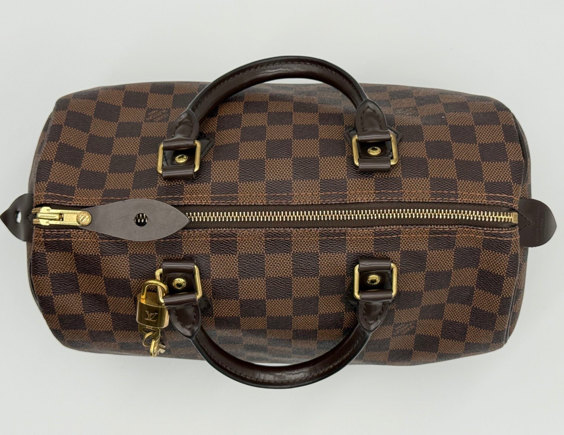 Louis Vuitton Speedy 30 shown at an angle, highlighting the rounded silhouette and Damier Ebène canvas