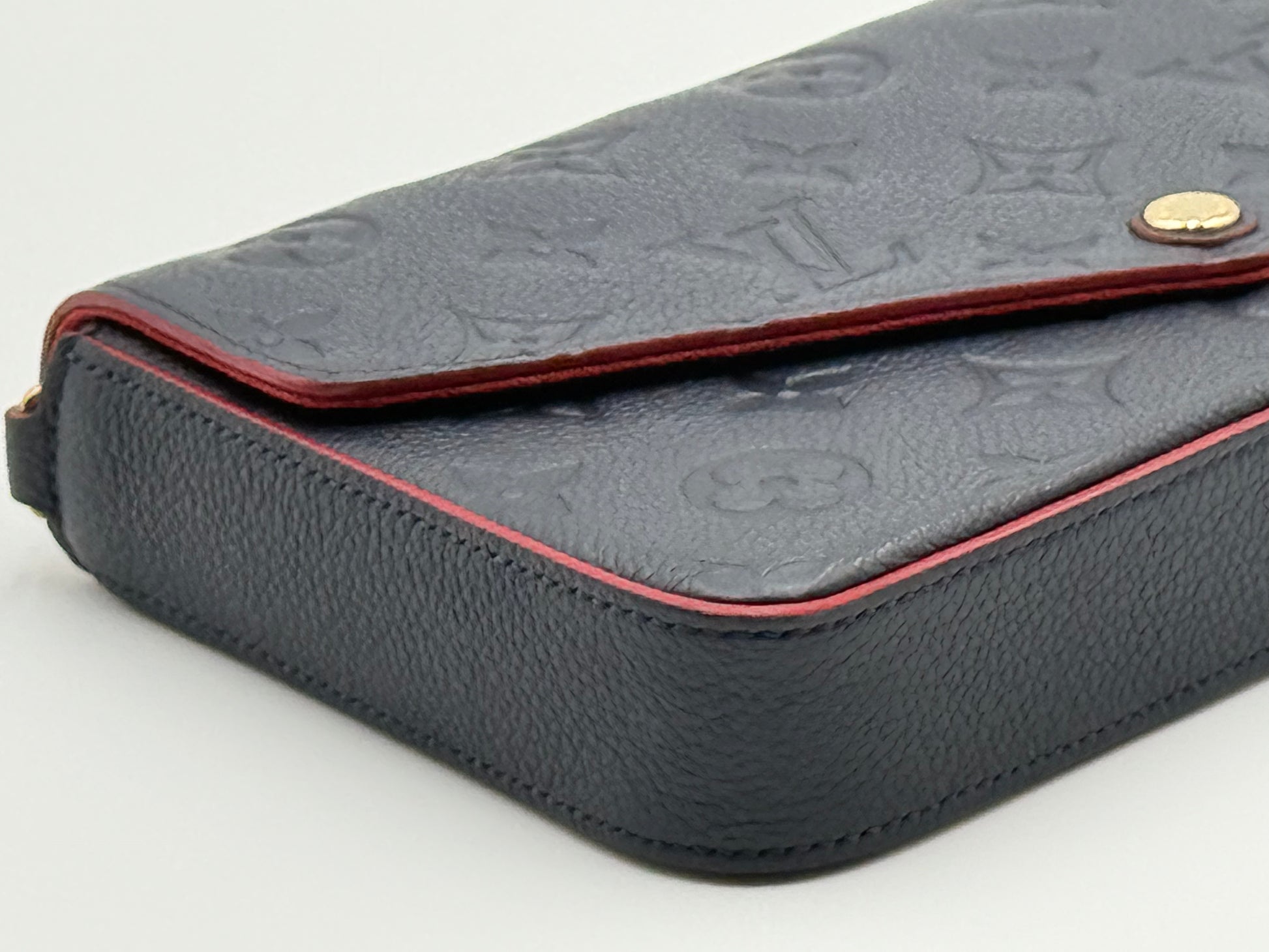 Louis Vuitton Félicie Pochette Empreinte Marine Rouge — angled side view showing red edge paint