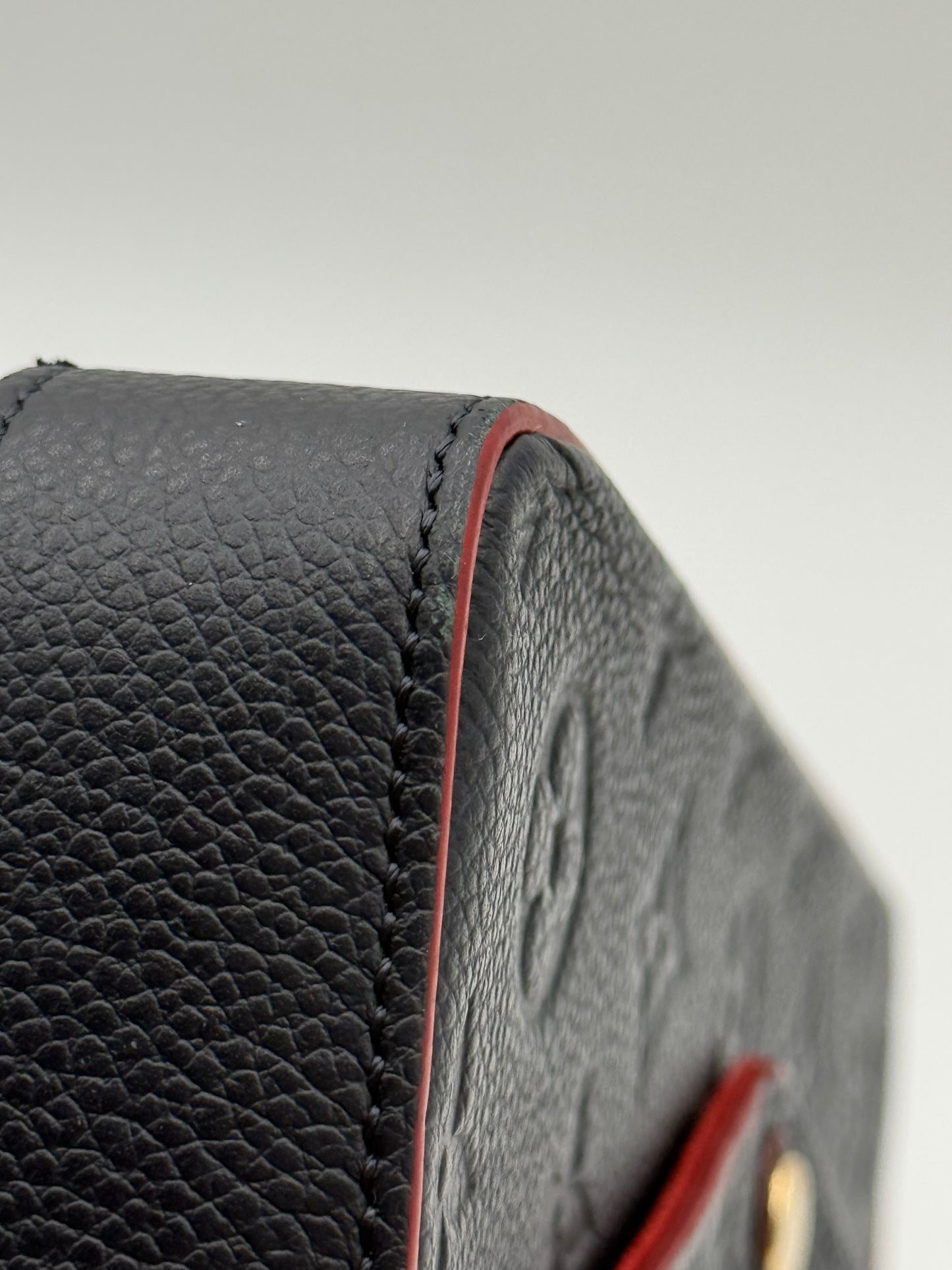 Louis Vuitton Félicie Pochette Empreinte Marine Rouge — close-up of embossed Monogram leather and edge wear