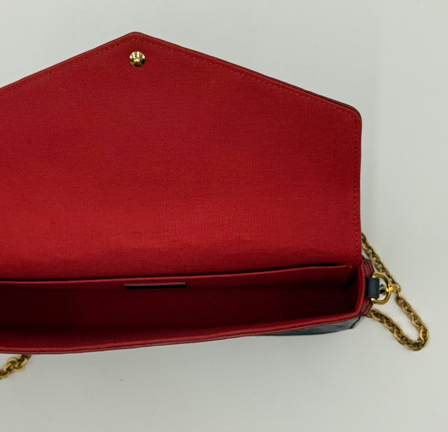Louis Vuitton Félicie Pochette Empreinte Marine Rouge — open flap showing red textile interior