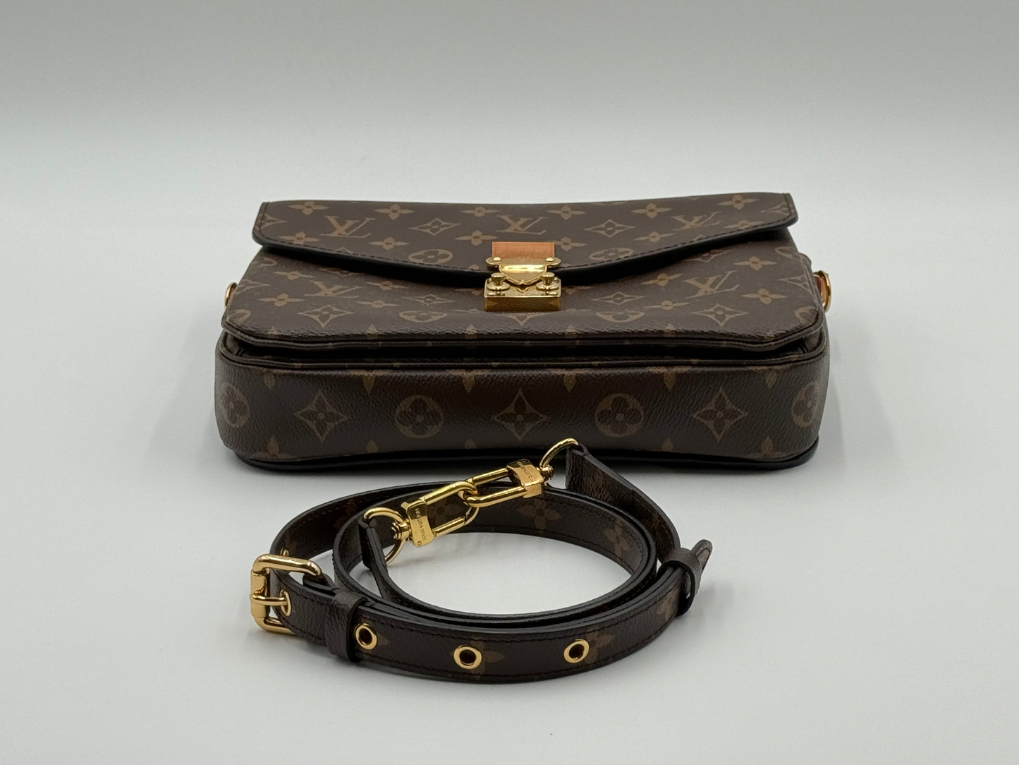 Louis Vuitton Pochette Métis Monogram — flap and S-lock from above
